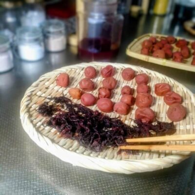 ザルに補した梅干しと絞った赤しそを広げる