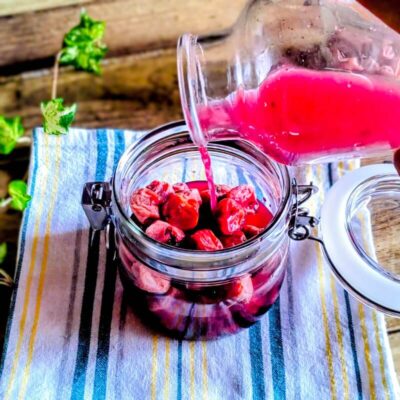 保存瓶に入れた梅干しに梅酢を注ぐ